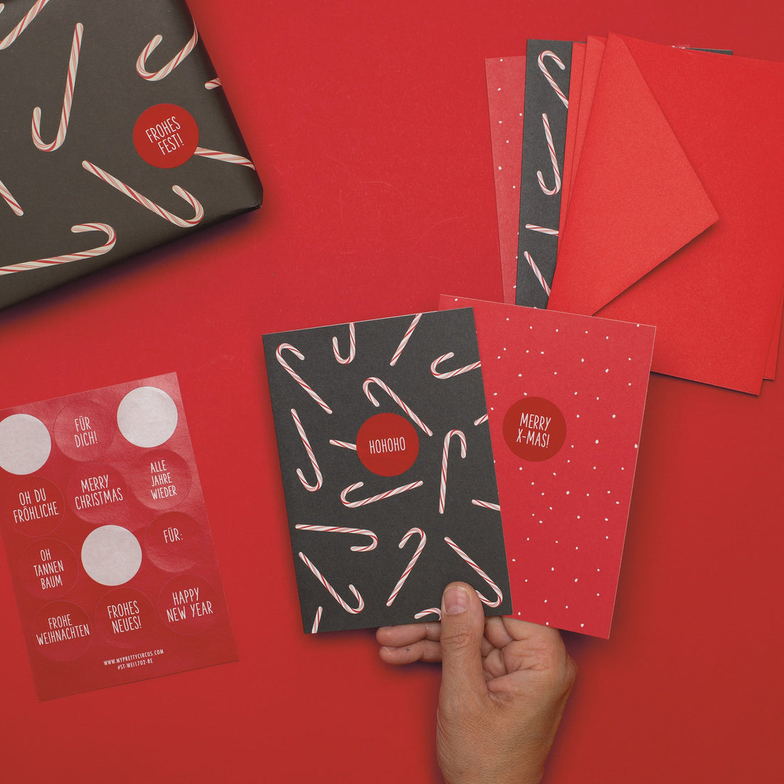 Karten mit Zuckerstangen auf Grau und Rot mit weißen Pünktchen, mit Grußstickern auf Deutsch, Umschlägen und Geschenk